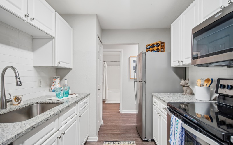 A kitchen with white cabinets and stainless steel appliances at The Chapman pet friendly apartments in Rochester.