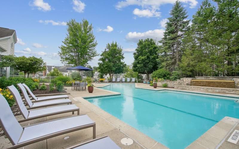 A pool with lounge chairs at The Chapman apartments for rent in Rochester, MI.