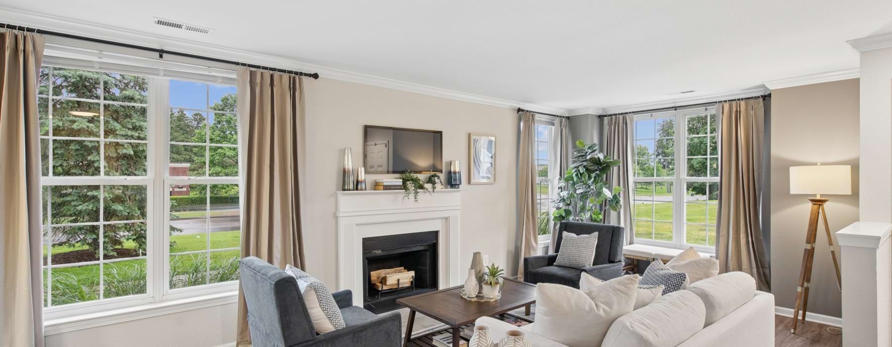 A living room with a couch and a coffee table, with views of a kitchen in a one bedroom apartment in Rochester at The Chapman.